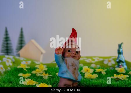 gnom with red bonnet and easter bunny on a flowering meadowland spring still-life Stock Photo
