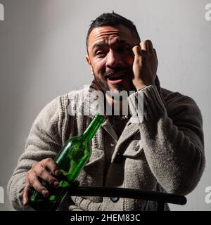 Alcoholic man with bottles wine cry. Depressed crying man. Drunk alcohol addict man drinking whiskey, depressed as alcoholic suffering alcoholism Stock Photo