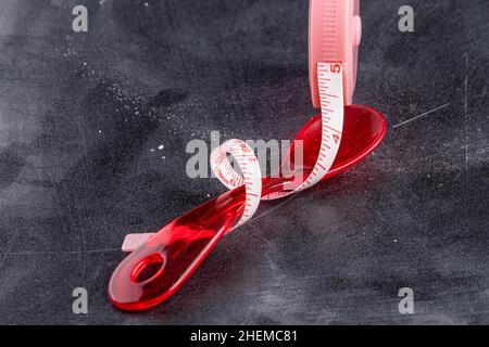 Measuring tape with red plastic spoon Stock Photo