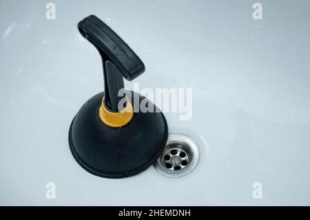 Plunger and clogged sink. Pipe cleaning concept. Sanitary engineering work. Stock Photo