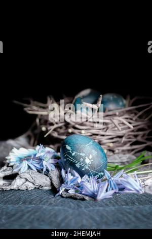 easter eggs in a round bird's nest with processed hay on the background of the nest, monochrome Easter still life in a rustic style in very bright col Stock Photo