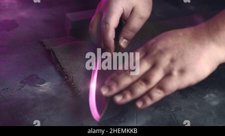 Process of sharpening chef knife on whetstone close up. Stock Photo