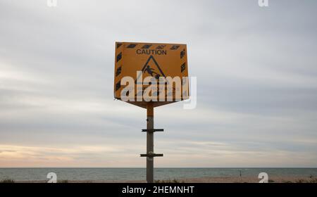 Yellow warning sign alerting against climbing rocks. Stock Photo