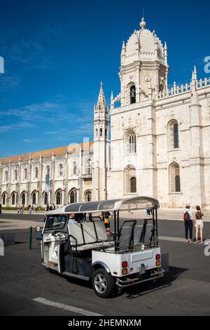 a Tuk Tuk Taxi in front of the Mosteiro dos Jeronimos in Belem near the City of Lisbon in Portugal.  Portugal, Lisbon, October, 2021 Stock Photo