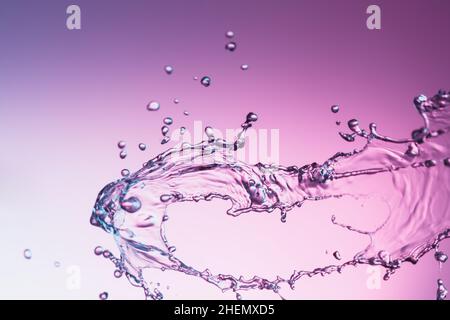Clear water liquid splash on a purple color background Stock Photo