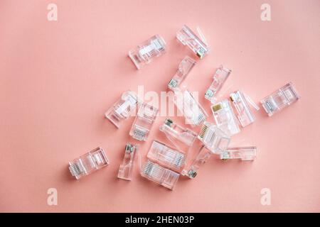 Transparent ethernet internet RJ-45 connectors, tehnology background on pink. LAN connectors plug. Stock Photo