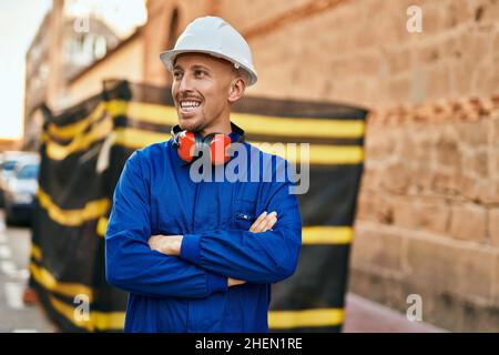 Young caucasian worker smiling happy wearing uniform at the city. Stock Photo