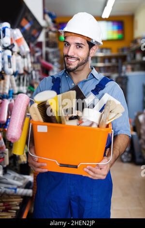 Happy male builder with tools in hands in shop Stock Photo