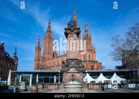 market church in Wiesbaden with historic market pillar from 19th century with fountain under blue sky Stock Photo