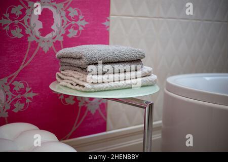 A stack of towels on a shelf dryer for things in the bathroom Stock Photo
