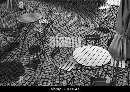 Outdoor German cafe seating with round tables and wooden  chairs Stock Photo