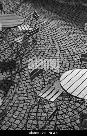 Outdoor German cafe seating with round tables and wooden  chairs Stock Photo