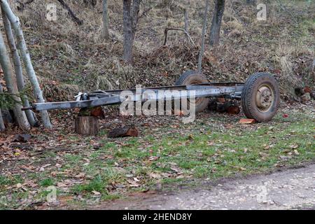 Handmade empty metal timber trailer parked on a country road near the forest Stock Photo