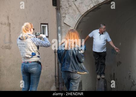 Riga, Latvia - August 29, 2021. Two girls with photo cameras on a travel tour. Tourists with smartphones take photos in Old City. Family photoshoot Stock Photo