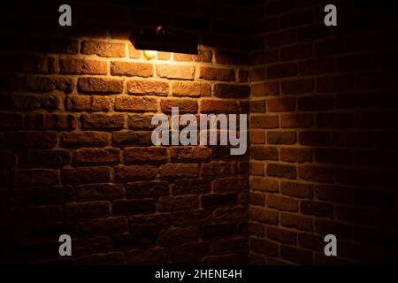 Brick wall illuminated by warm light from a lamp Stock Photo