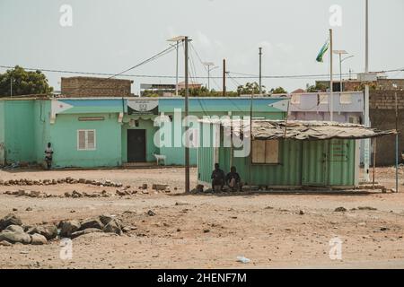 Djibouti, Djibouti - May 21, 2021: Two Djiboutian man sitting in front of a international phone booth. Editorial shot in Djibouti Stock Photo