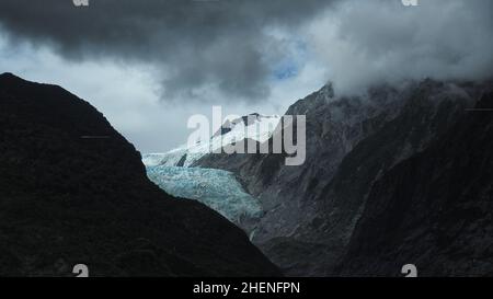 The terminal face of Franz Josef glacier in storm clouds, New Zealand Stock Photo