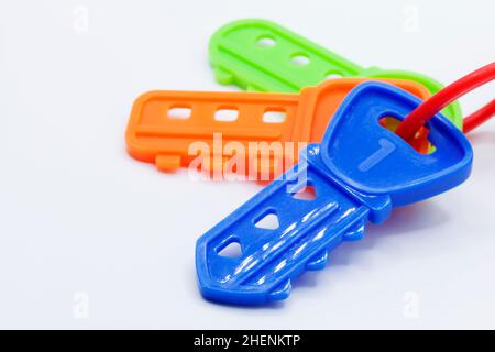 three plastic toy keys in different colors on a white background Stock Photo
