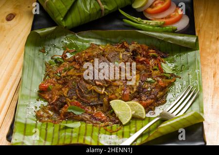 Meen Pollichathu or fish pollichathu, tasty kerala dish, fish with masala cooked in banana leaf. Stock Photo