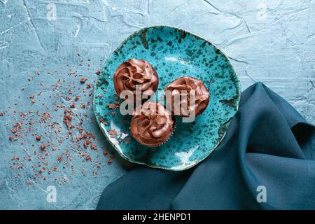 Plate with tasty chocolate cupcakes on color background Stock Photo