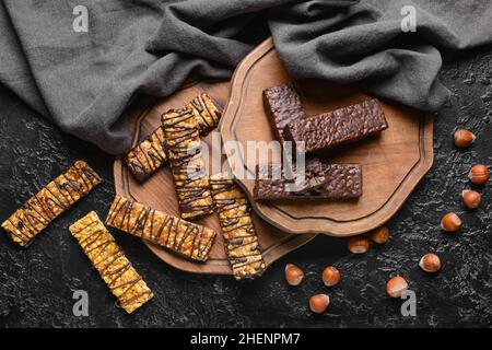 Boards with tasty chocolate nut bars on dark background Stock Photo