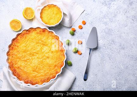 Baking dish and pot with tasty English fish pie on light background Stock Photo