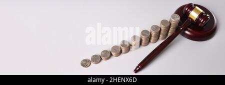 Wooden judge gavel and stacks of coins on table Stock Photo