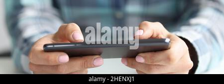 Black smartphone in female hands at workplace Stock Photo