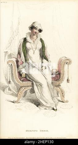 Regency woman in morning costume seated on a sofa, 1812. Dress of superfine Scotch cambric over a slip, ruff a la Mary Queen of Scots, Flora cap in satin and lace, capuchin cloak of blossom satin. Plate 26, Vol. 7, April 1 1812. Handcoloured copperplate engraving by Thomas Uwins from Rudolph Ackermann's Repository of Arts, London. Stock Photo