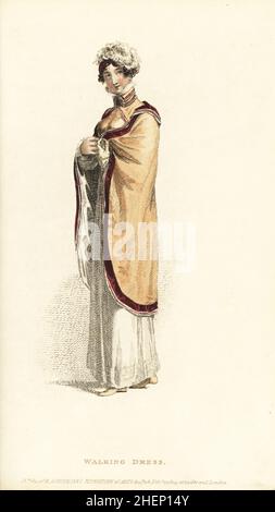 Regency woman in promenade dress. Round high robe of fine cambric, Russian mantle of pale salmon colour, bordered with morone velvet and white silk cord, spencer bodice, small helmet bonnet with ostrich feathers, half boots, lemon kid gloves. Plate 12, Vol. 10, February 1, 1814. Handcoloured copperplate engraving from Rudolph Ackermann's Repository of Arts, London. Stock Photo