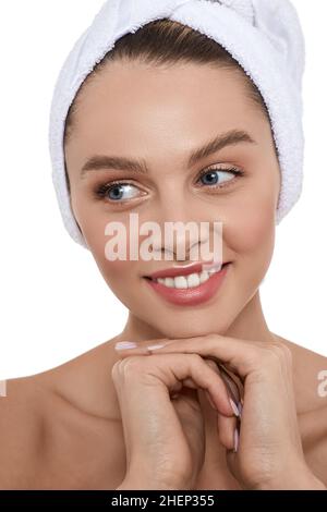 Happy woman with moisturized fresh skin with towel on head after bath procedures. Body care concept Stock Photo
