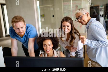 Group of software engineers working developing applications together in corporate office Stock Photo