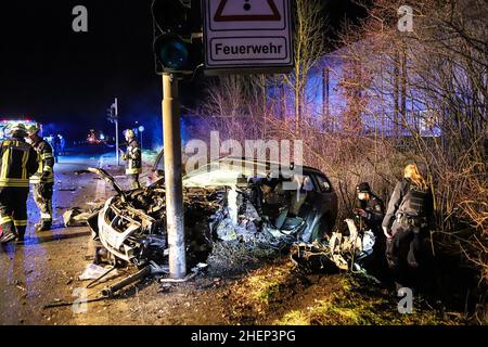 11 January 2022, North Rhine-Westphalia, Hagen: Rescue workers from the Hagen fire department are working on the totally destroyed vehicle. A motorist drove his car into a traffic light pole in Hagen and was seriously injured. The motorist was drunk at the time of the accident on Tuesday evening and did not have a driver's license, as a police spokesman said on Wednesday morning. The car was a total loss, he said. The man had to be freed from the car by rescue workers and was taken to a clinic in Bochum. (to dpa: 'Drunk man drives car into traffic light pole - seriously injured') Photo: Alex T Stock Photo