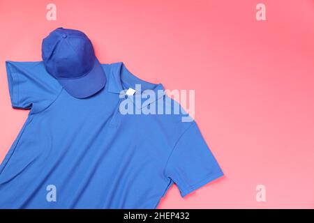 Blank t-shirt and cap on pink background Stock Photo