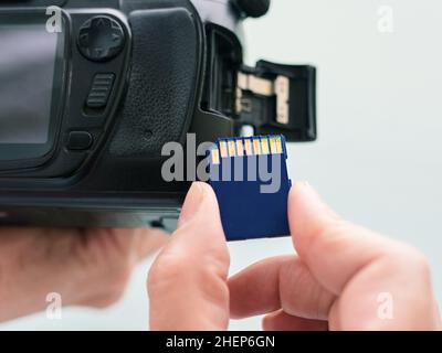 Sd card in hand and digital camera Stock Photo