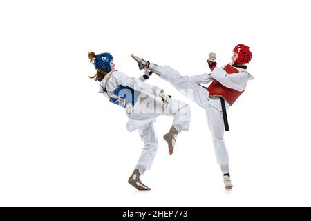 Portrait of two young women, taekwondo athletes practicing, fighting isolated over white background. Concept of sport, skills Stock Photo