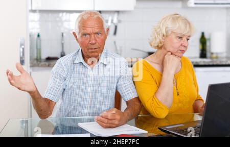Unhappy mature couple with documents having conflict in home Stock Photo
