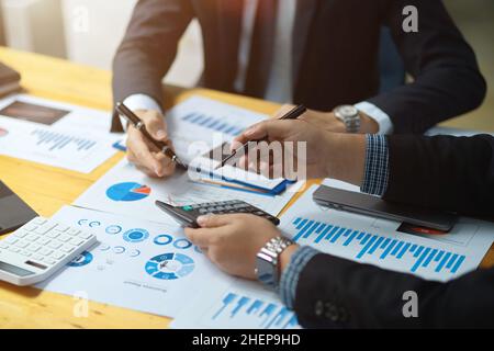 Male boss discussing and analysing his business financial data with his financial analysts in the meeting. Stock Photo