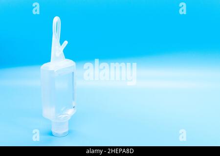 Clear hand sanitizer keychain isolated on a blue background. Stock Photo