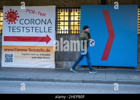 Munich, Germany. 12th Jan, 2022. A man walks past signs at the Deutsches Museum pointing to a Corona testing station. Credit: Peter Kneffel/dpa/Alamy Live News Stock Photo