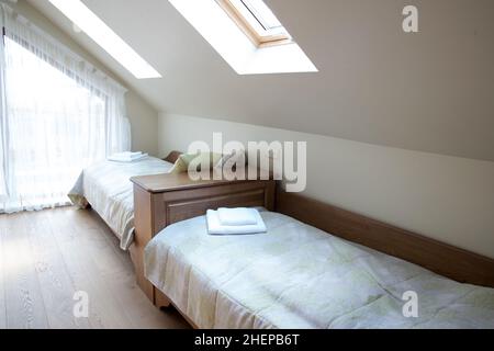 bedroom interior in light pastel tones and sloping roof Stock Photo