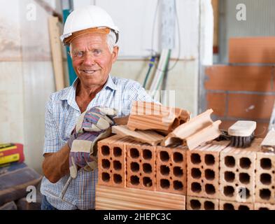 Happy bricklayer near brick stack Stock Photo
