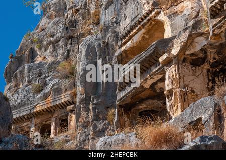 fragment of famous complex of rock tombs in the ruins of Myra with reliefs on the cliff Stock Photo