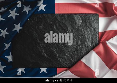 Black stone plaque on the American flag with place for text Stock Photo