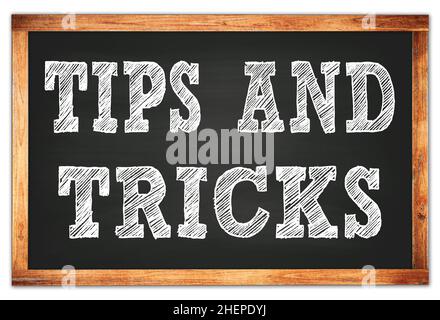 TIPS AND TRICKS written on black wooden frame school blackboard Stock Photo