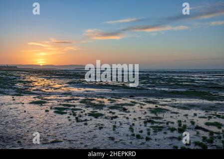 Sunset over Hoylake beach on the river Dee estauary looking to Wales over Hilbre Island. Stock Photo