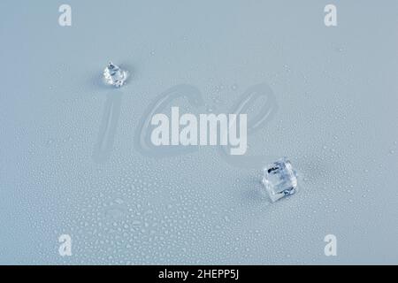 Inscription ice on a wet gray background with two ice cubes Stock Photo