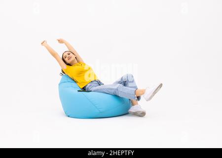 Young woman sit in bag chair look camera isolated on white background. People lifestyle concept