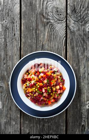Vinegret, russian vinaigrette, salad of diced cooked vegetables red beets, potatoes, carrots, chopped onions, brined pickles, green peas in a bowl on Stock Photo