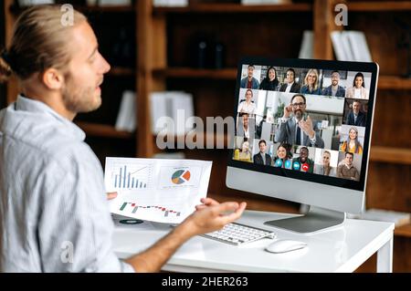 Brainstorming, online business meeting. Side view of a corporate employee communicating with a group of multi-ethnic colleagues via video call, analyzing financial statements, planning strategy Stock Photo